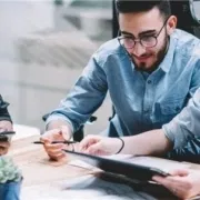 Business people gathered around table talking